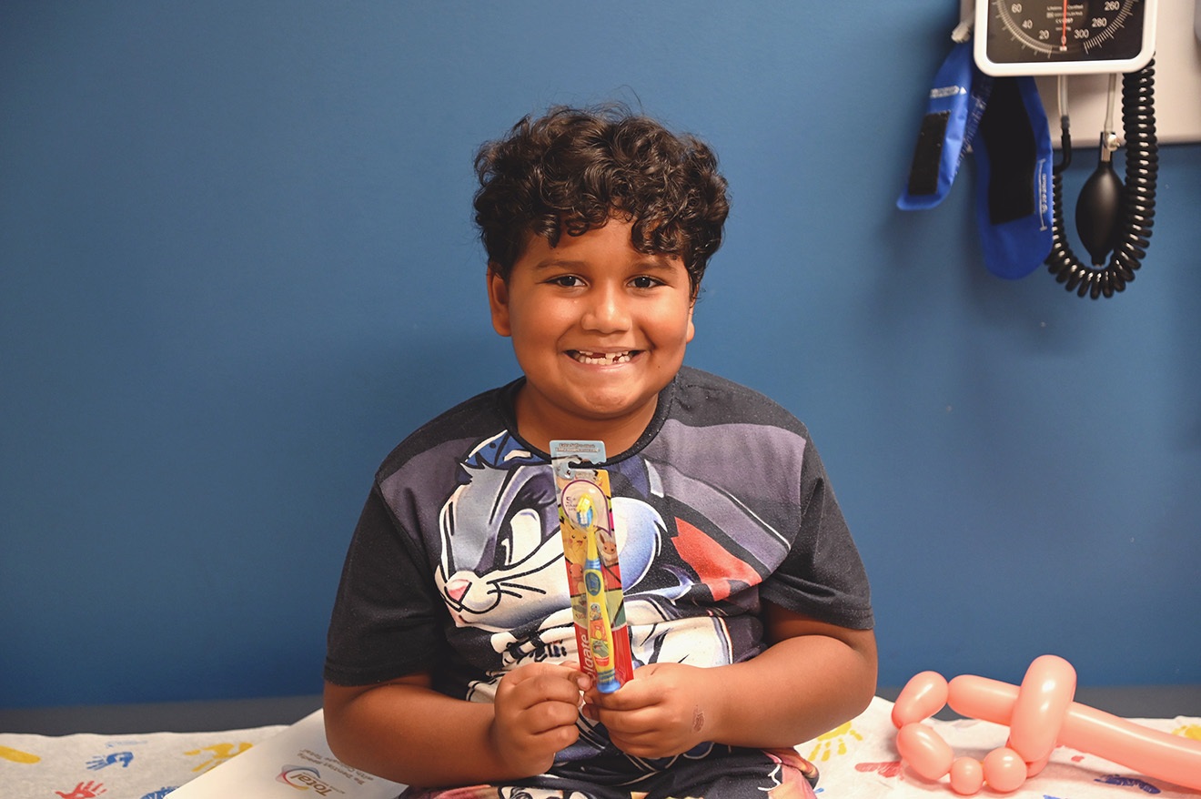 Child Holding Up Toothbrush